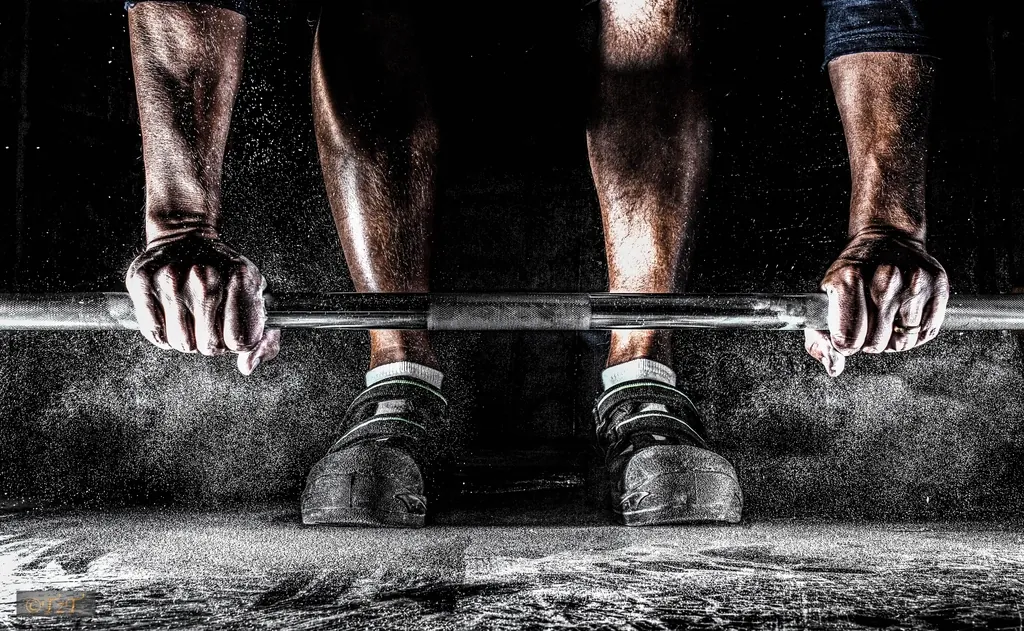 Persona levantando una barra cargada en la sala de musculación